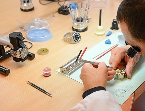 horloger de l’atelier montres à lyon en train de faire une réparation de montre sur une montre de luxe d’occasion