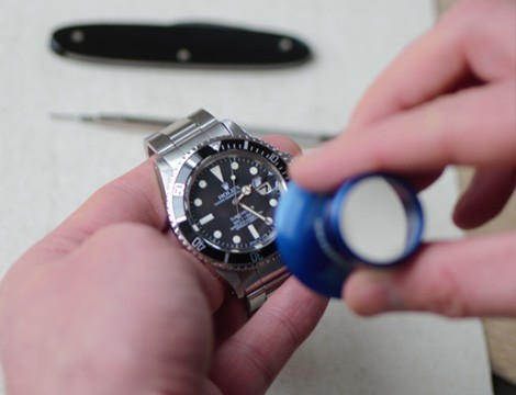 horloger de l’atelier montres à lyon en train de faire une réparation de montre sur une montre de luxe d’occasion