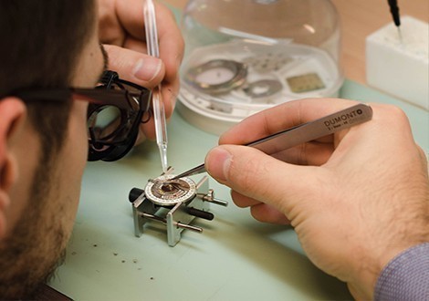 horloger de l’atelier montres à lyon en train de faire une réparation de montre sur une montre de luxe d’occasion